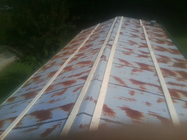 Rusted metal roof panels with new wood purlins before replacement — Storm Damage Roof Repair in Mitchells by Roofing Brothers