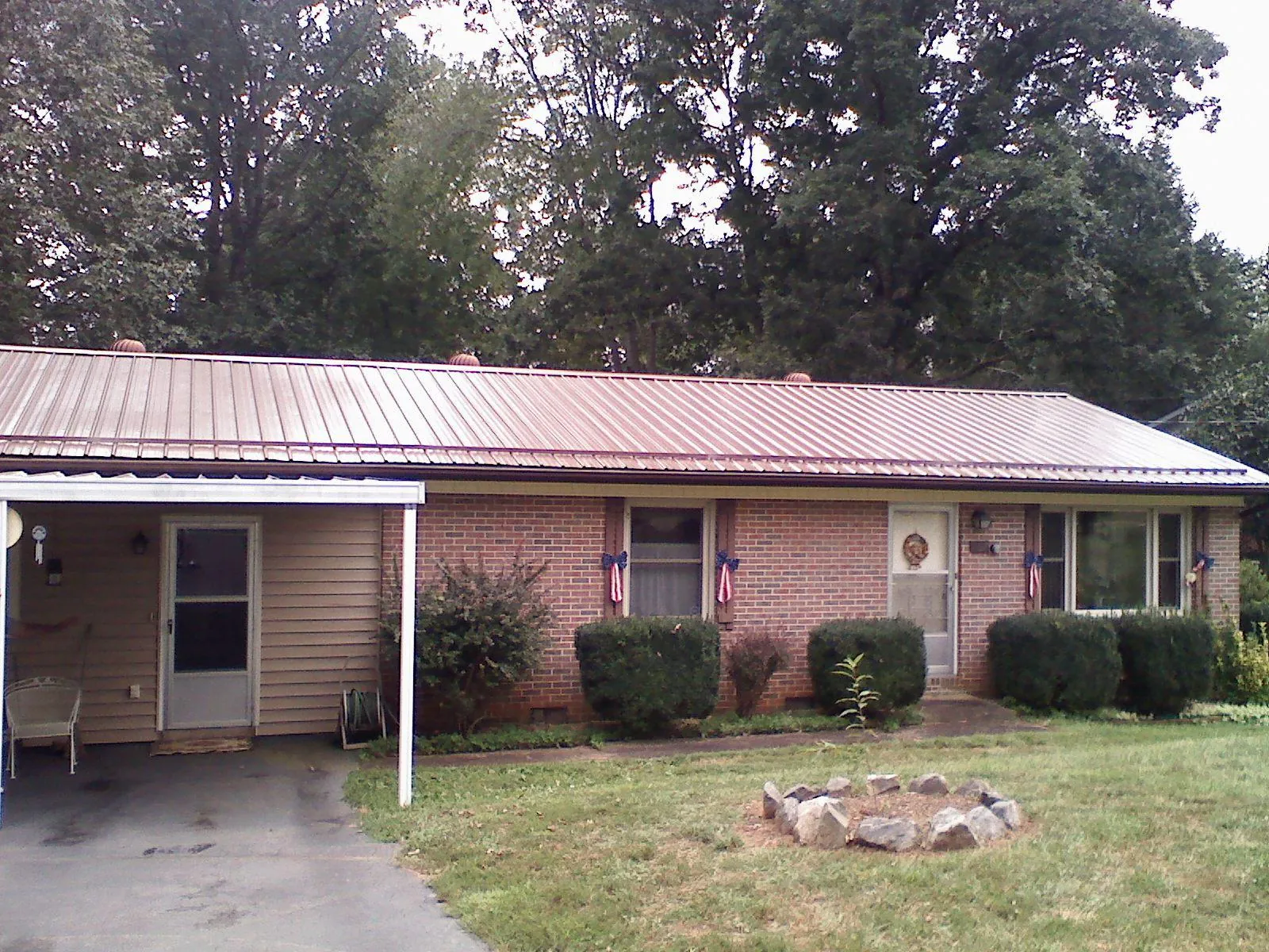 Bronze metal roof and carport on a brick ranch home — Roof Repair work by our crew in Mitchells