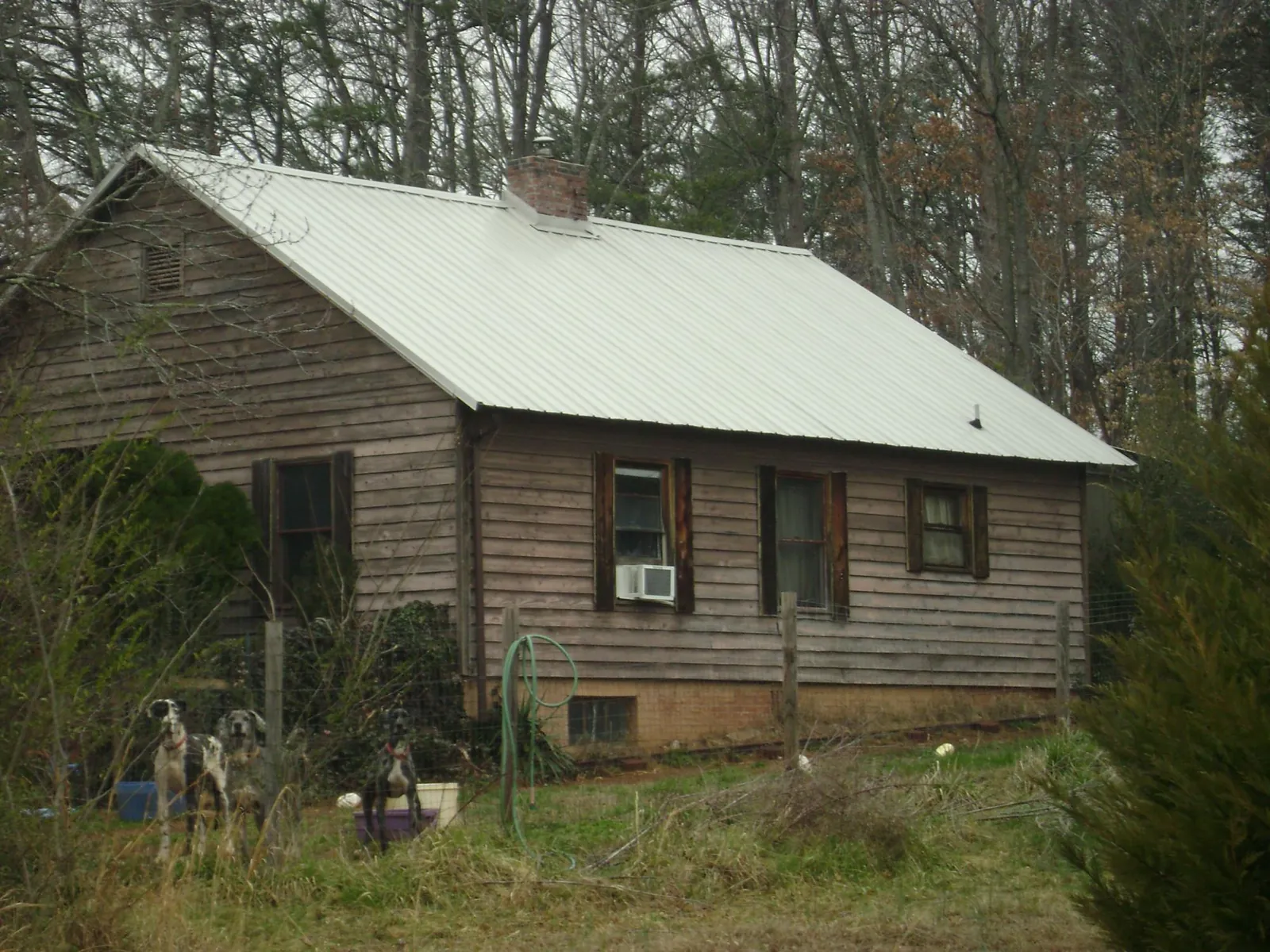 White metal roof on an old wood sided farmhouse, from a Metal Roof Installation job in Mitchells